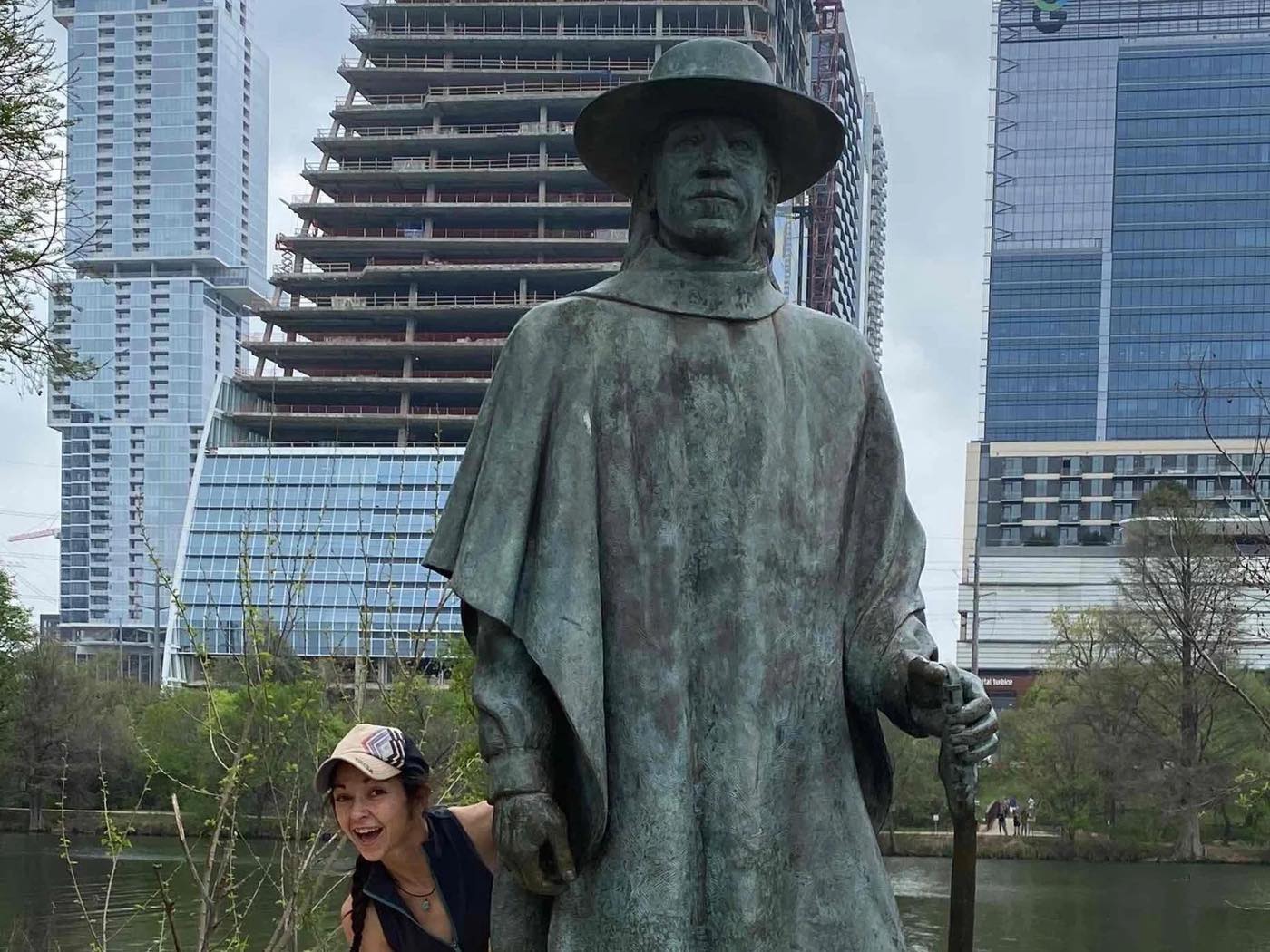 A player peeks out from behind a bronze statue for a Roamli photo challenge