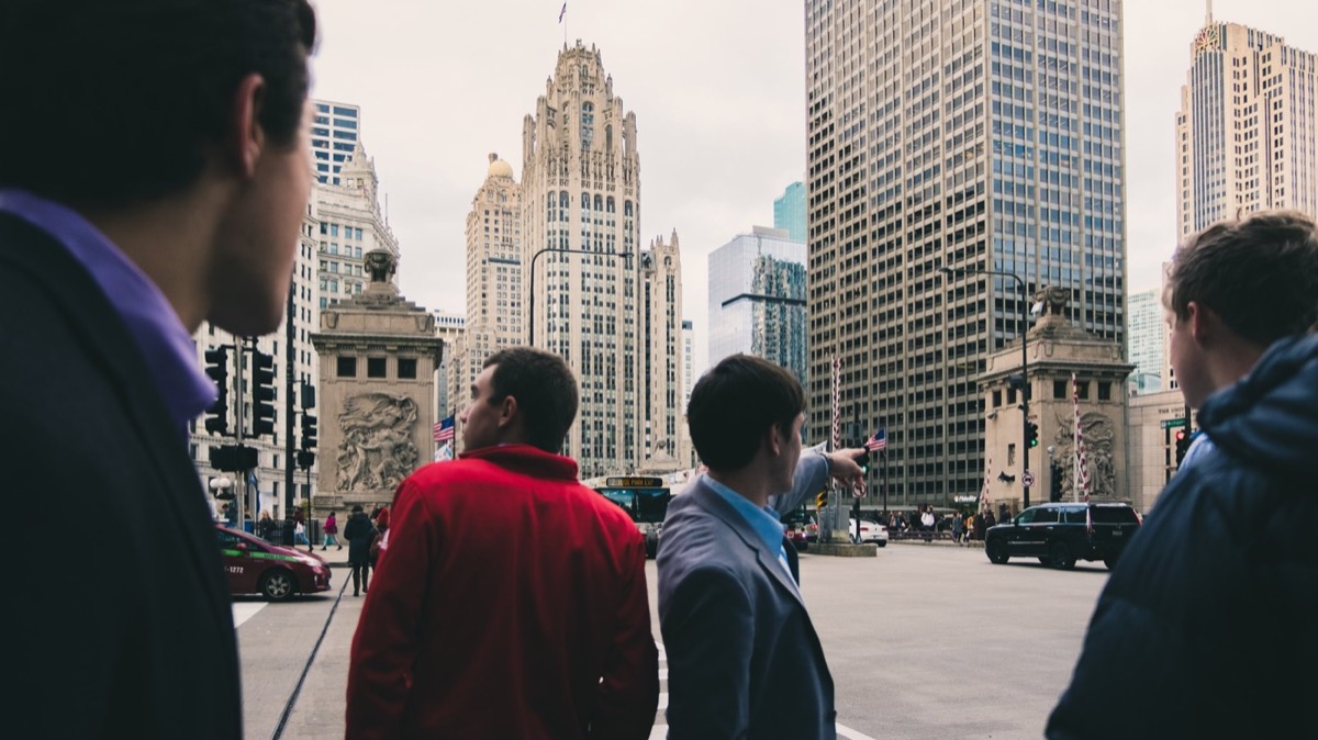 A small group points out landmarks on a busy downtown Chicago street
