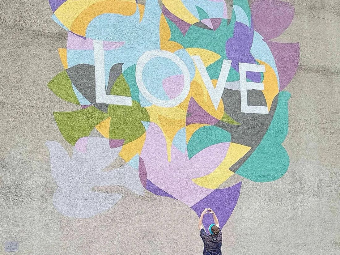 A player poses in front of a LOVE mural