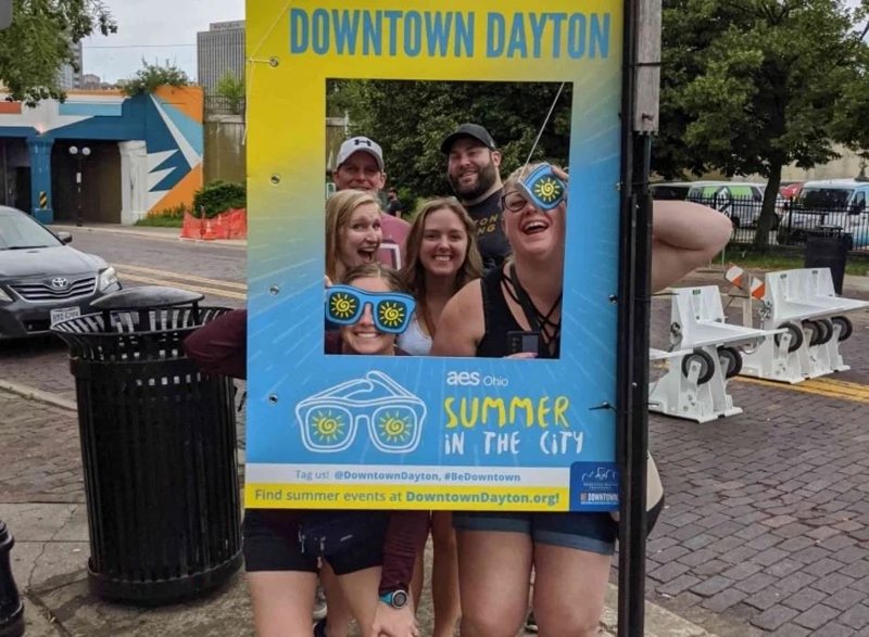 Players crowd into a giant Downtown Dayton photo frame during the Downtown Adventure